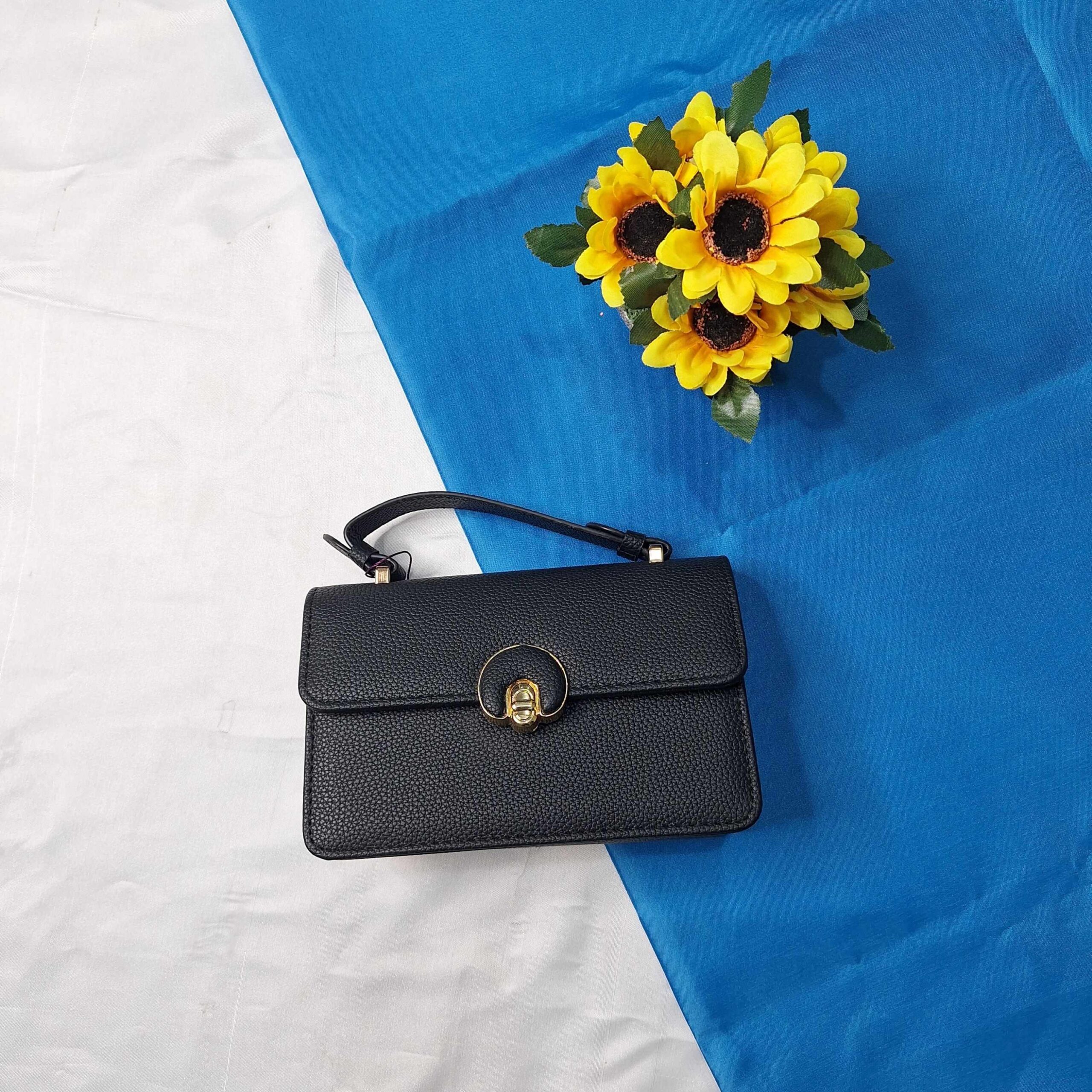 Black leather handbag with a gold clasp